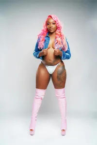 A confident woman with pink hair and tattoos, representing the empowerment some users feel from supportive AI relationships.
