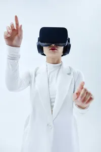 A person in a white outfit wearing a VR headset interacts with a virtual interface.
