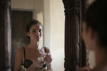 A woman looking at her reflection, symbolizing self-exploration through AI companionship.